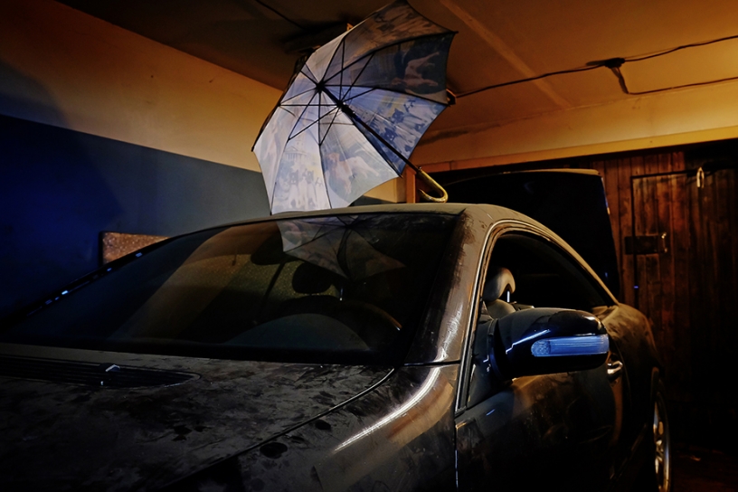 Umbrella on top of a dust covered car