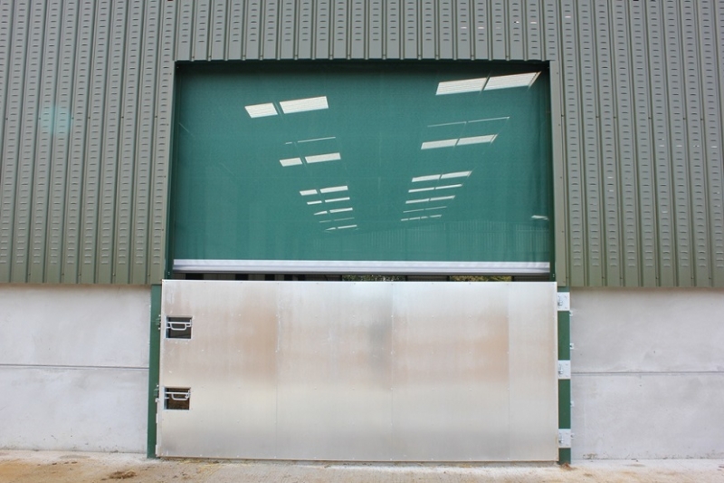 A Galebreaker mesh screen protecting the opening above a barn swing door