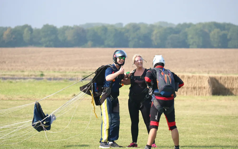 Three people who have just landed from skydiving