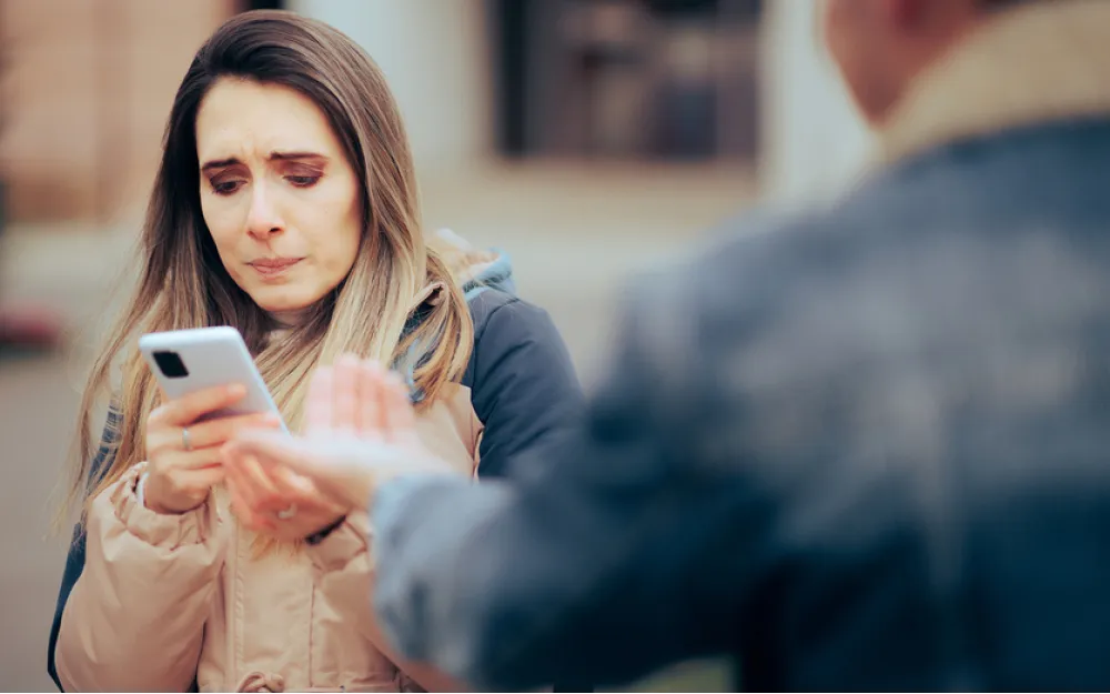 woman checks phone of suspicious partner