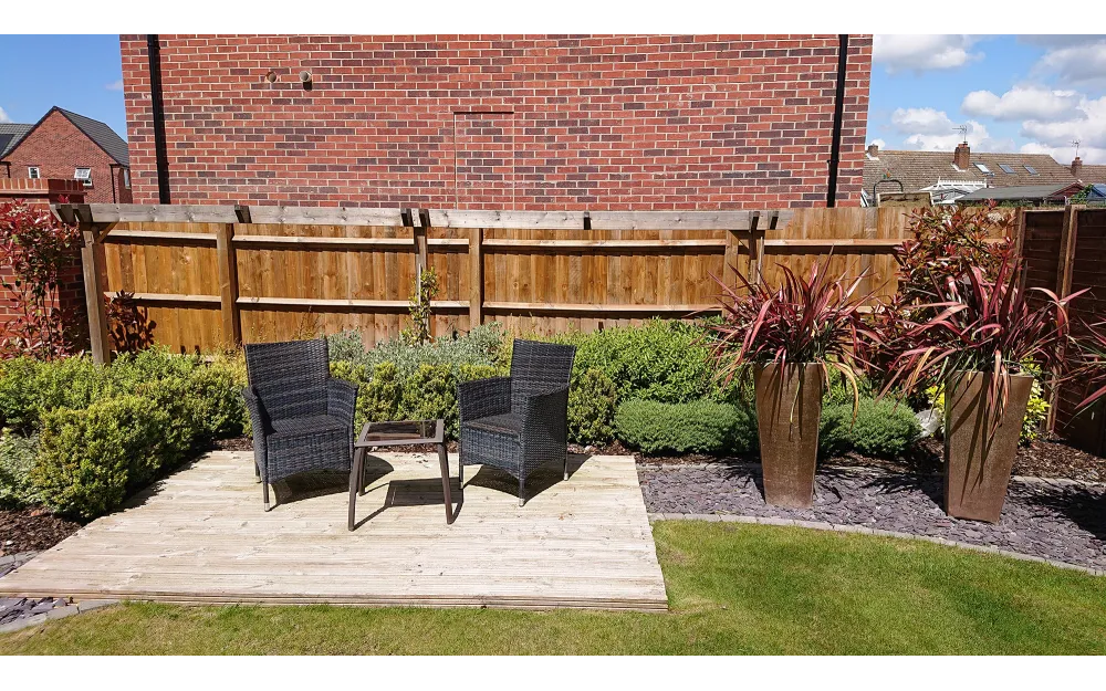 Two garden chairs sitting in front of close board fencing